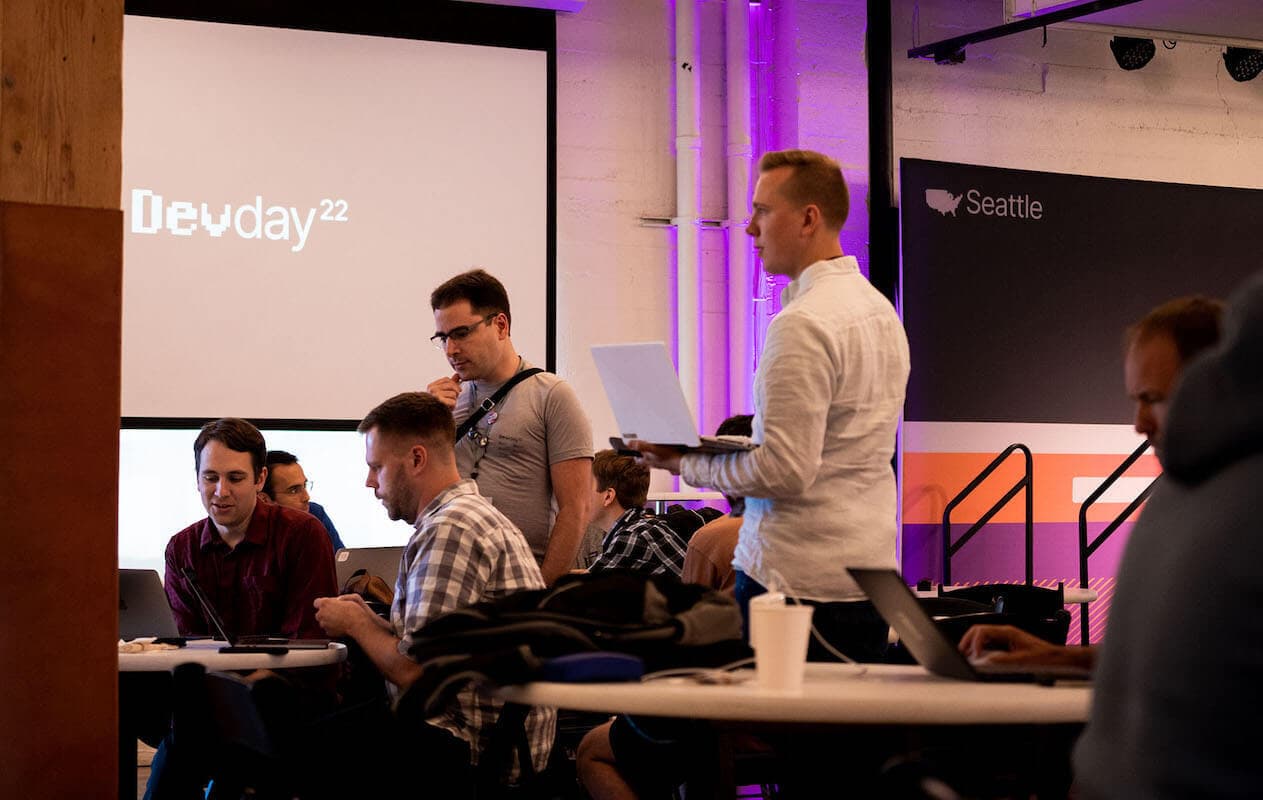 A group of engineers collaborating around a table, including Aaron Parecki, a Security Architect from Okta.